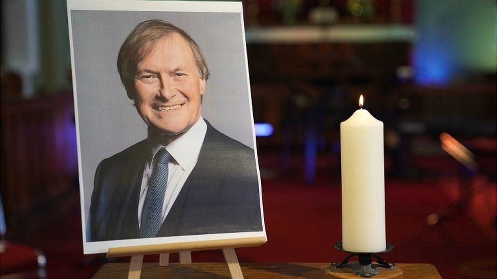 A candle and photo of Sir David Amess at church in Leigh-on-Sea