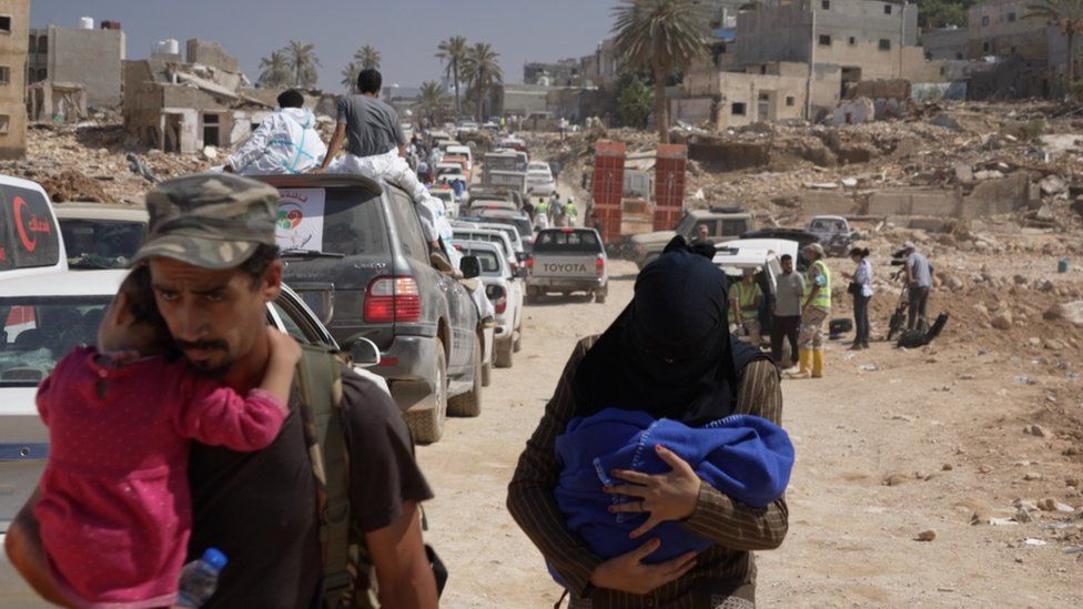 People in Derna, Libya, carry children to safety