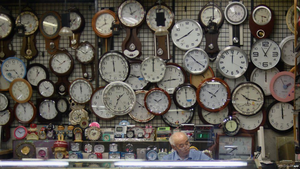 A watch and clock vendor sits in his shop in Seoul on 29 July 2015
