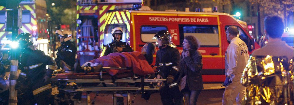 Medics move a wounded man near the Boulevard des Filles-du-Calvaire after an attack 13 November 2015 in Paris, France