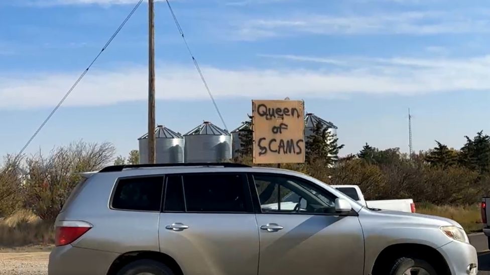 Part of Sunday's protest against the camp inside the school. A sign reads Queen of Scams