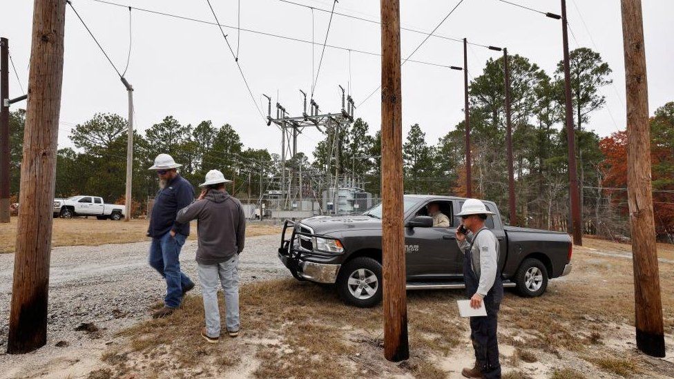 Workers successful  Moore County stitchery  astir   a pick-up motortruck  astatine  1  of the substations arsenic  they program  connected  however  to measure  the harm  and hole  it