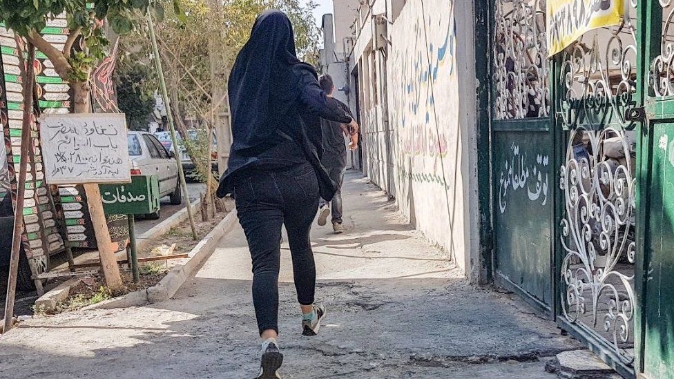 A woman appears to run away from a protest in Tehran, Iran