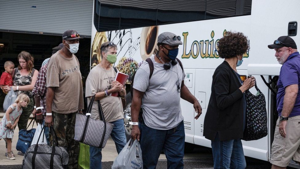 People board a bus during evacuations in Lake Charles, Louisiana