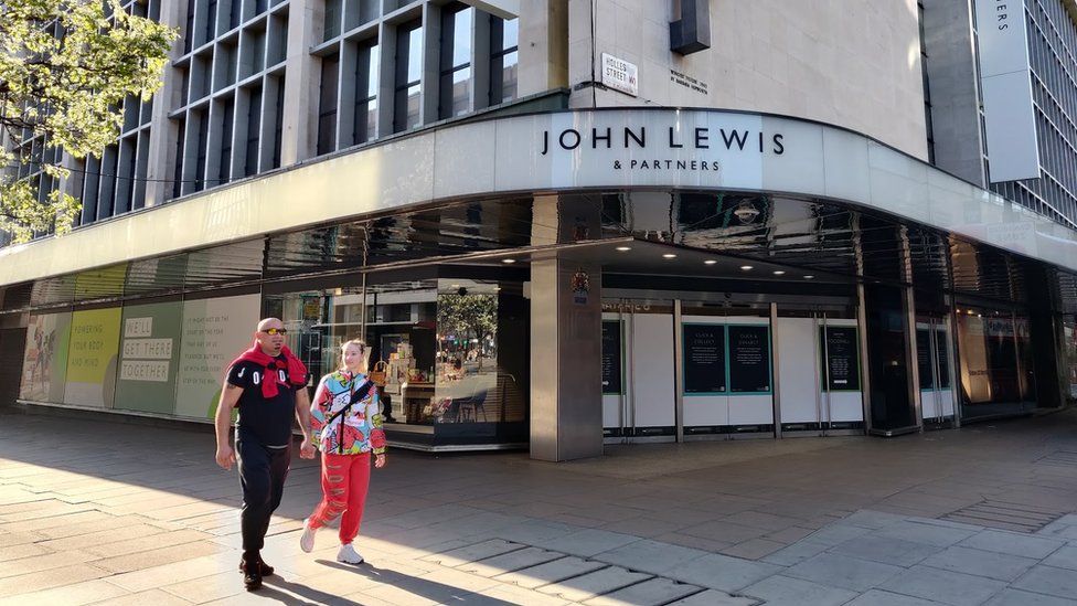 Two people walk past John Lewis on Oxford Street