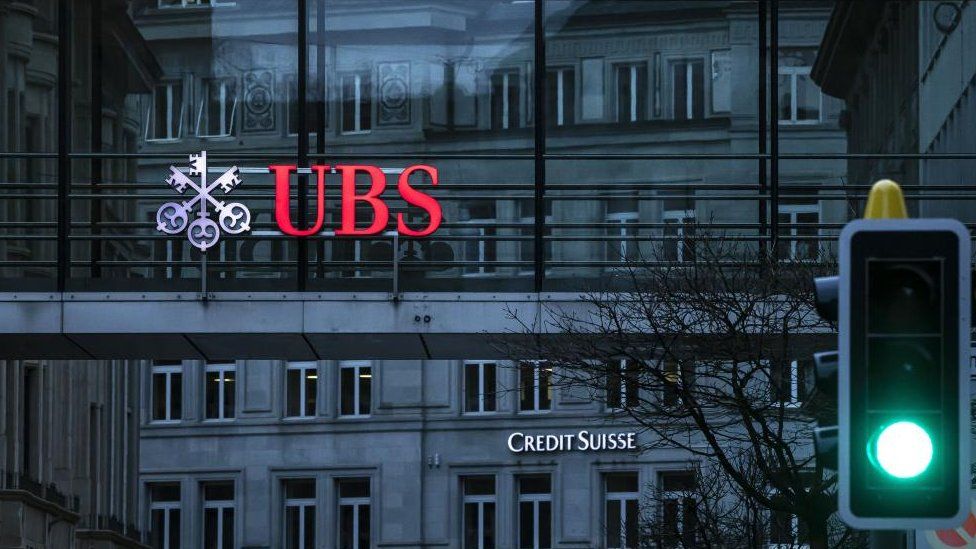 Logos of UBS and Credit Suisse on separate buildings
