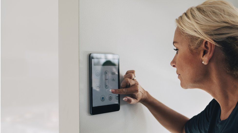 Generic image of woman turning down thermostat