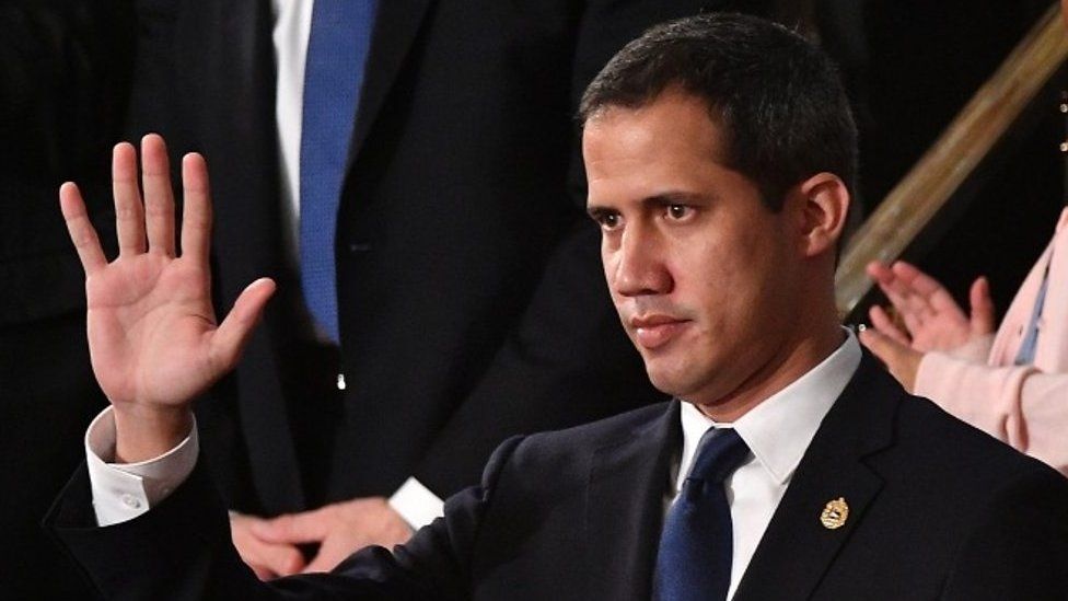 Venezuelan opposition leader Juan Guaidó waves as he is acknowledged by US President Donald Trump