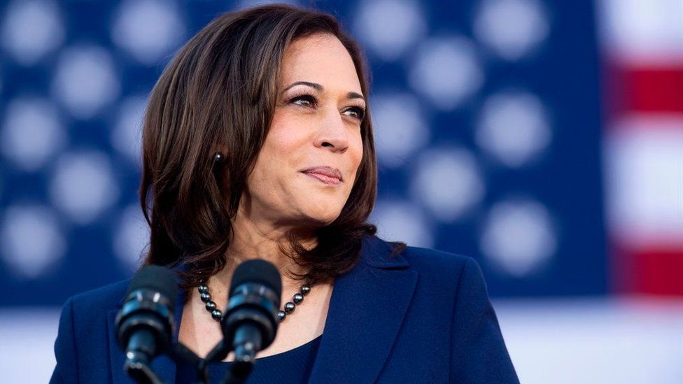 Kamala Harris standing in front of an American flag