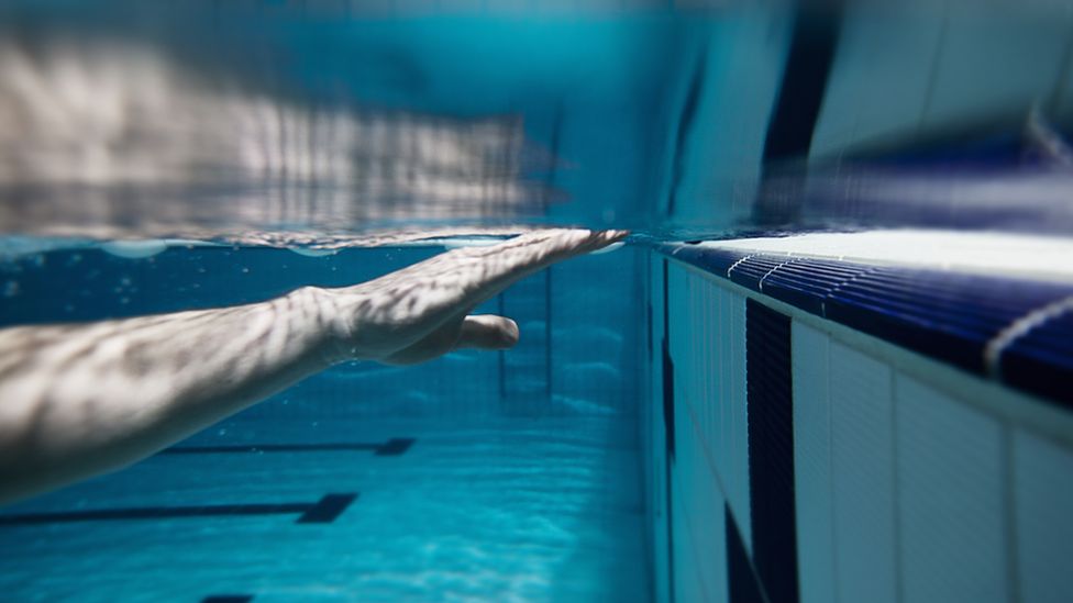 Swimmers hand touching the edge of the pool