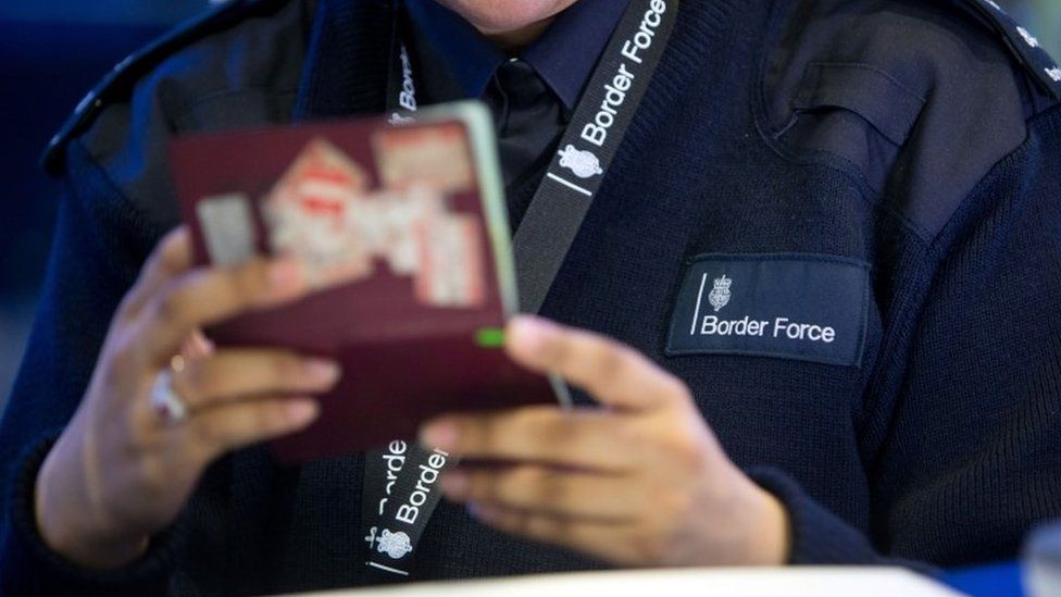 Border Force official checking passport