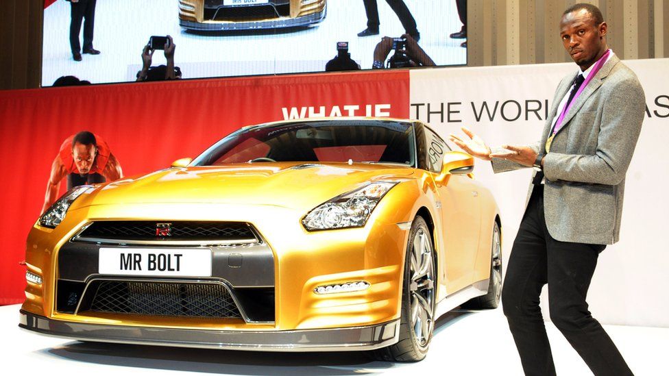Usain Bolt with a gold car