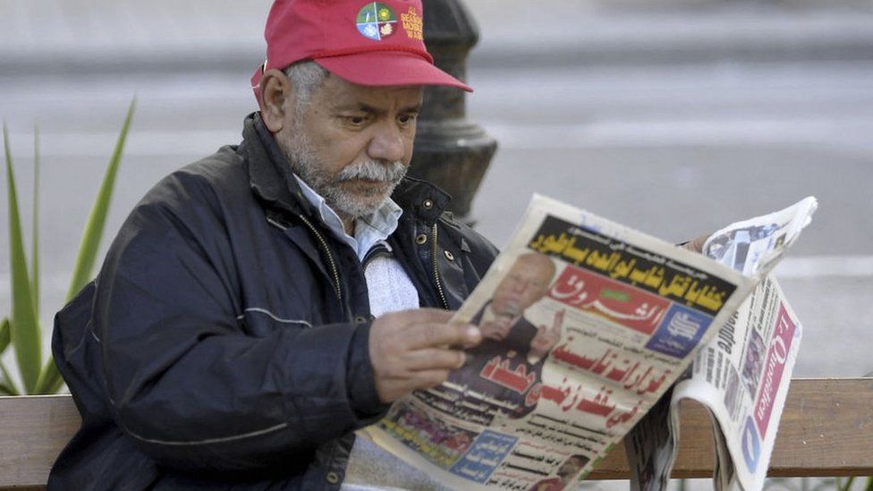 A Tunisian man reads a newspaper on Habib Bourguiba Avenue in the capital Tunis, December 2021