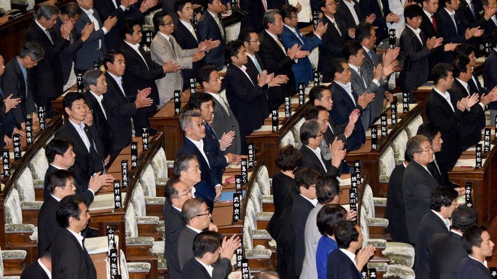 Members of Japan's lower house of parliament stand up to support a bill during the plenary session in Tokyo on June 2, 2017.