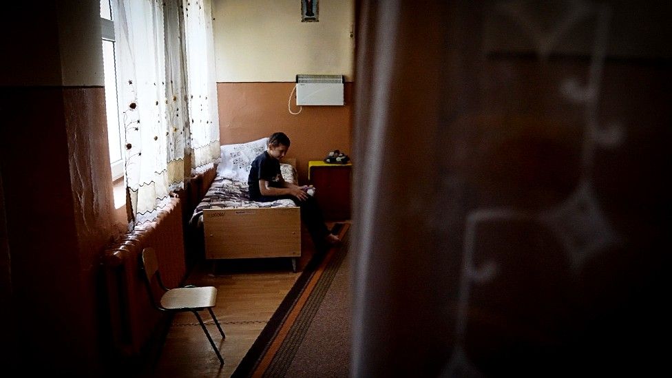 Criança na cama em orfanato ucraniano