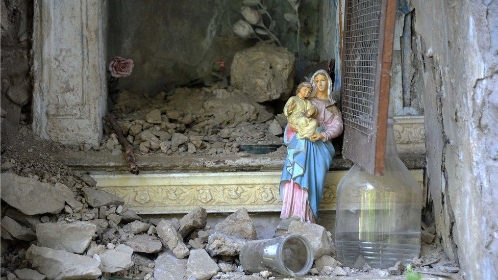 A Virgin Mary statue stands amid ruins in the Italian central town of Pescara del Tronto, on August 24, 2016