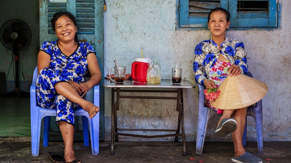 Two Vietnamese women drinking coffee together, Mekong River Delta, Vietnam