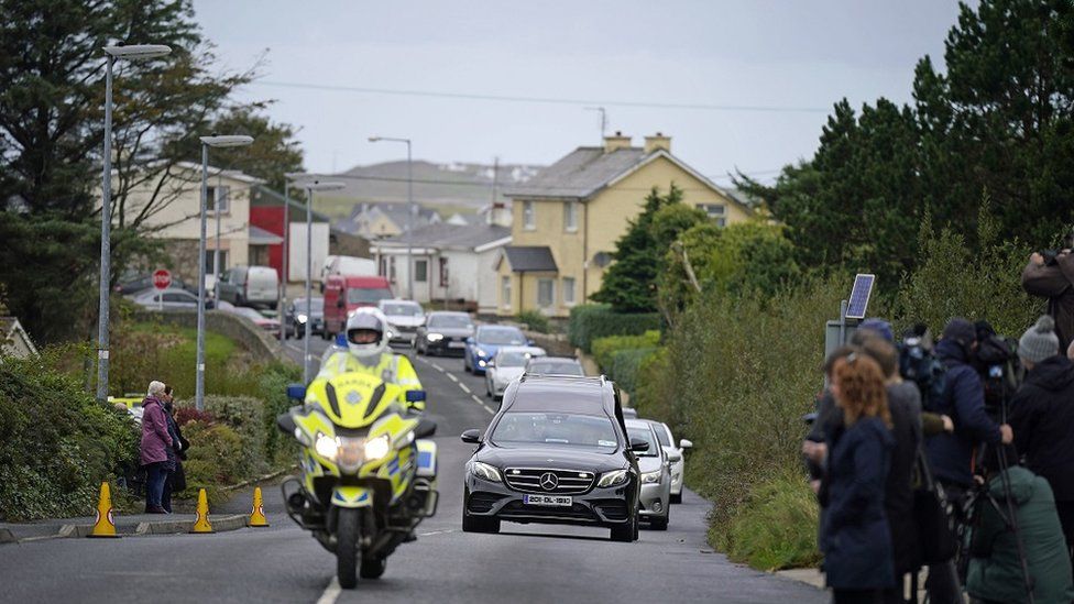 The hearse carrying the coffin of James O'Flaherty makes its way to St Mary's Church, Derrybeg for his funeral mass.