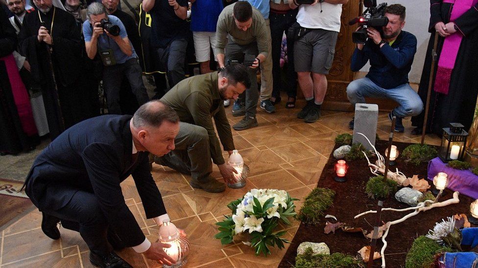 Ukraine's President Volodymyr Zelensky and his Polish counterpart Andrzej Duda (L) lay candles during service in Lutsk cathedral, 9 Jul 23