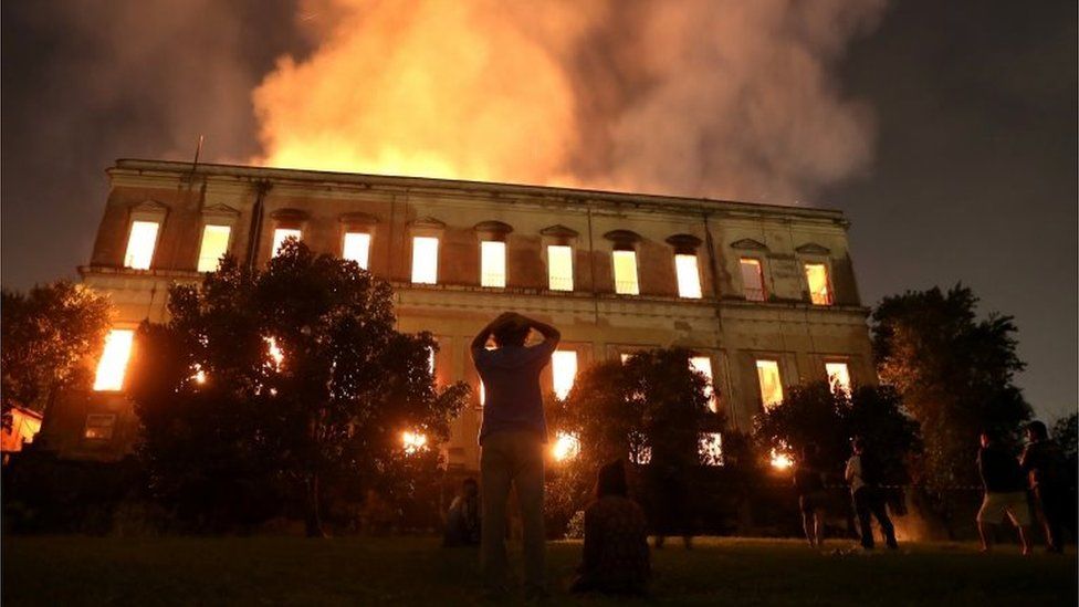People watch as a fire burns at the National Museum of Brazil in Rio de Janeiro, .