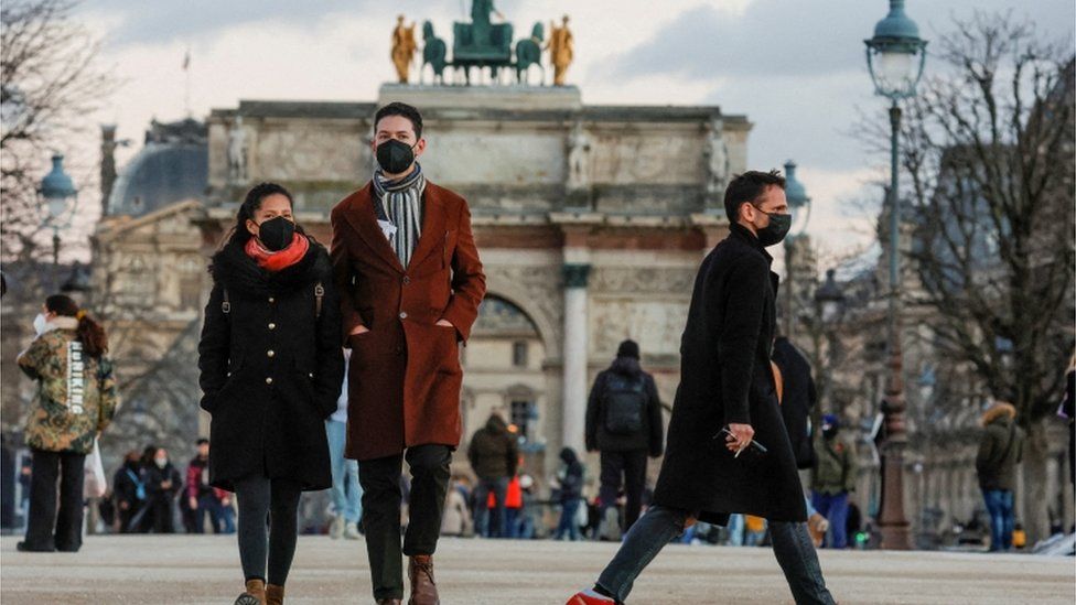People wearing protective face masks walk in the Tuileries Gardens in Paris amid the coronavirus disease