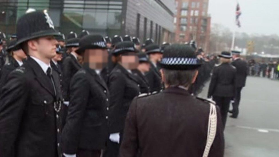 Still from footage of Ben Hannam in police uniform