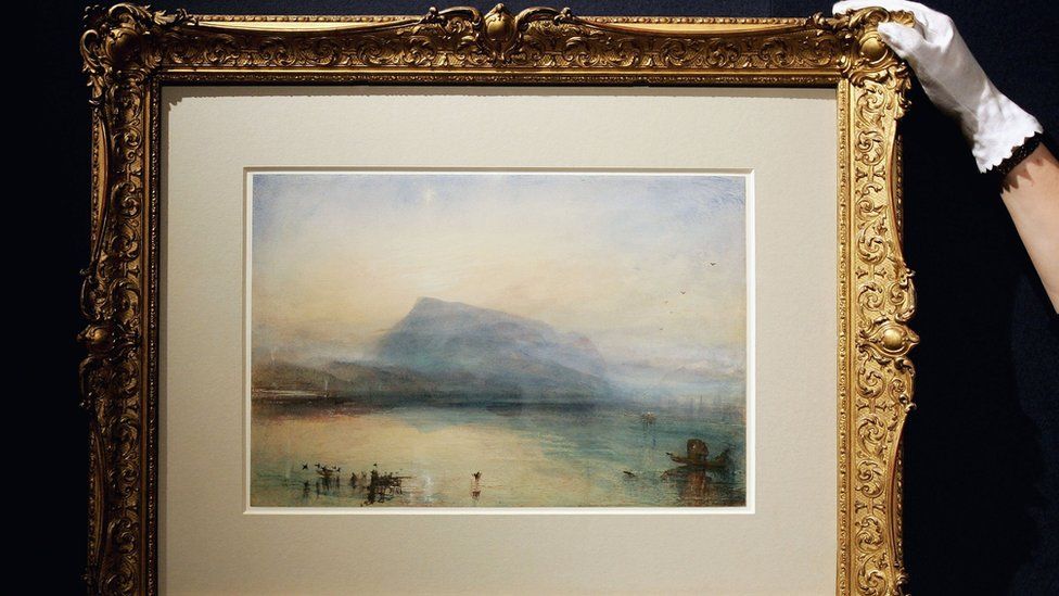 Sarah Rees of Christies straightens a J.M.W. Turner watercolour entitled "The Blue Rigi: Lake of Lucerne, Sunrise" at Christies Auction House