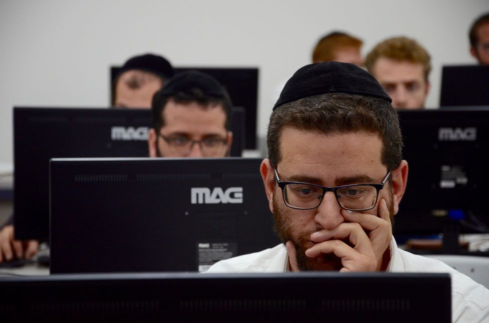 Men working at computer screens