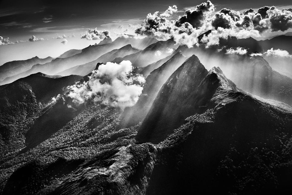 Black and white photograph of a cloud above mountains
