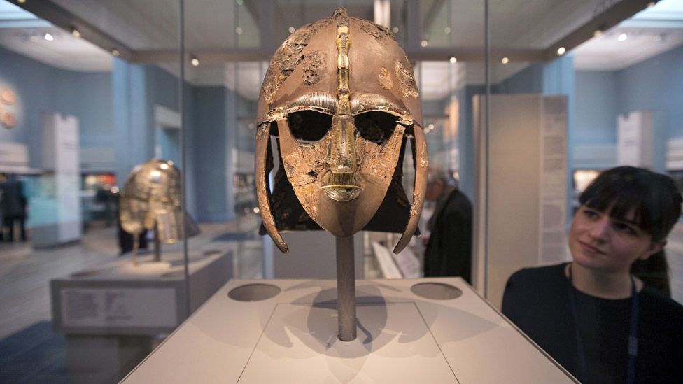 Женщина рассматривает шлем Саттон Ху, выставленный в новой галерее «Саттон Ху и Европа 300–1100 н. Э.» В Британском музее