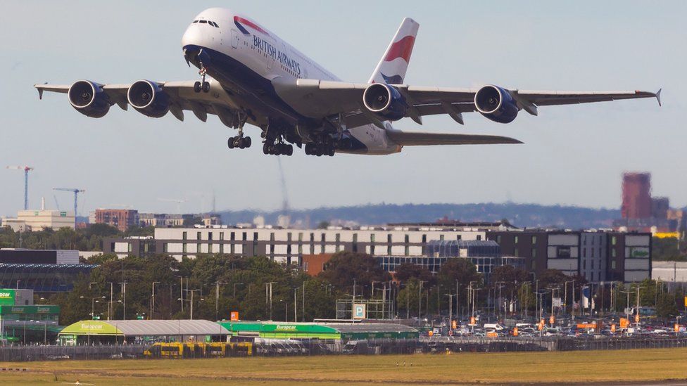 Plane takes off over scorched grass at Heathrow Airport