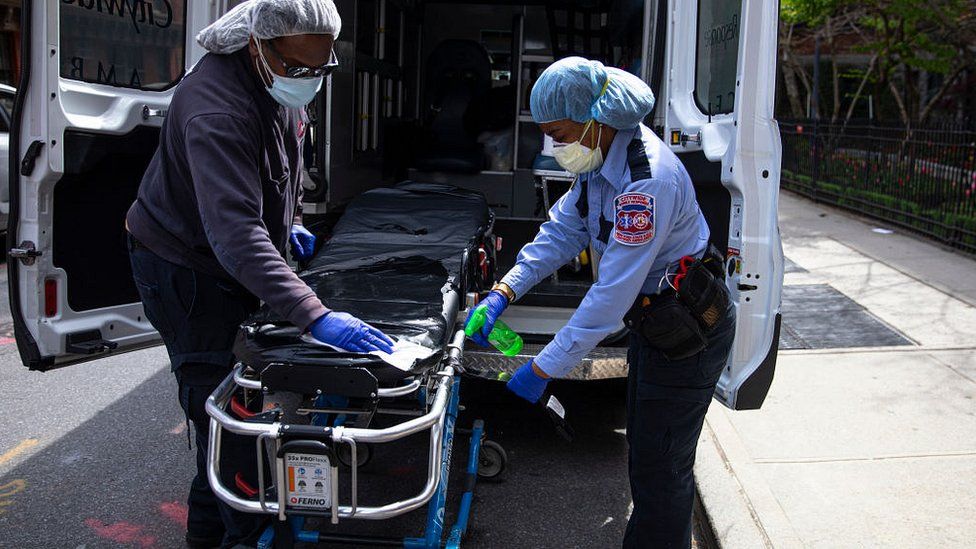 Medical staff of a private ambulance company sanitise a hospital gurney after they drop off a patient at the Cobble Hill Health Center April 20, 2020 in Brooklyn, New York City