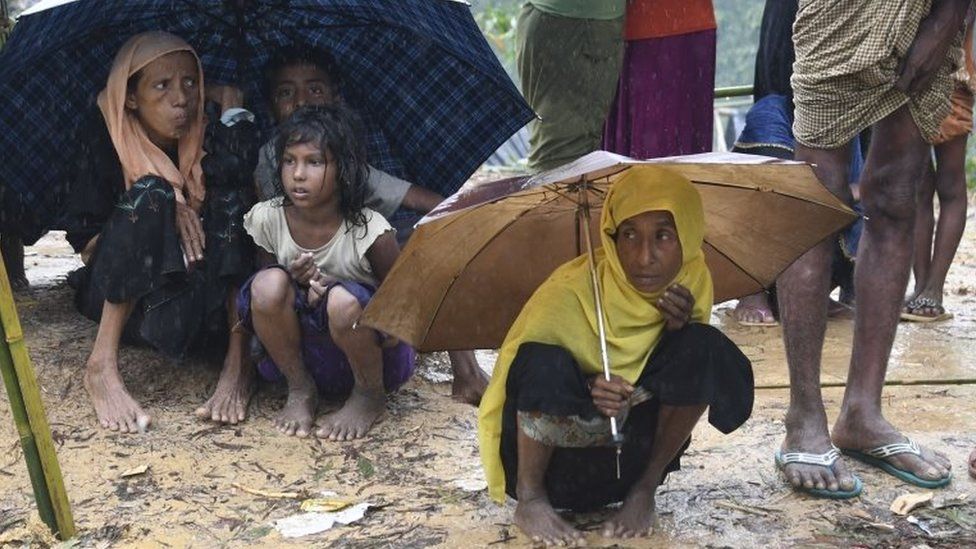 Rohingya Muslim refugees protect themselves from rain in Balukhali refugee camp near the Bangladesh town of Gumdhum on 17 September 2017.