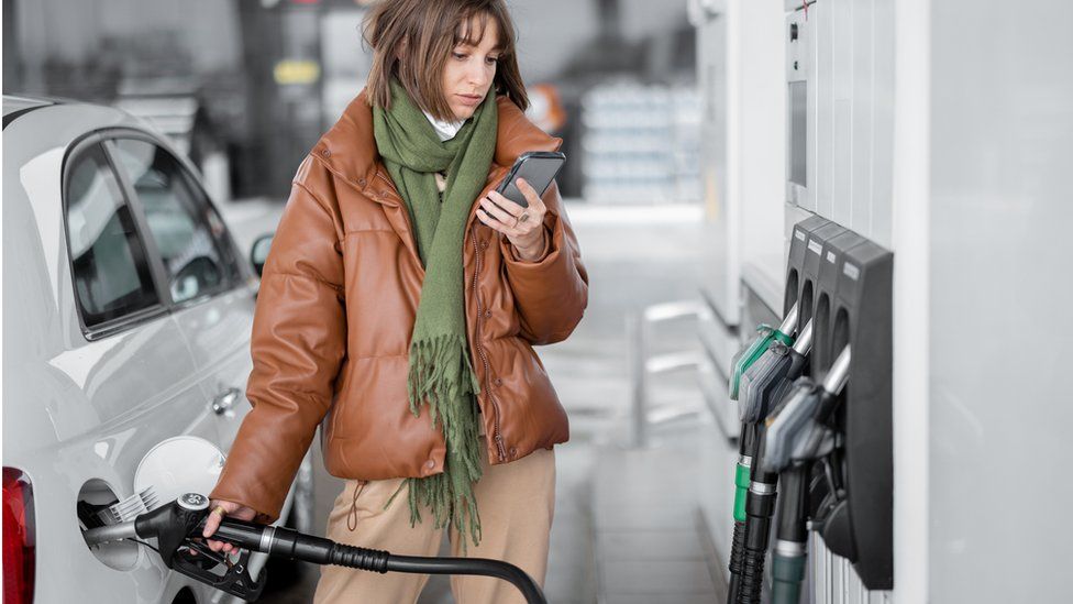 Woman filling a car with fuel - stock shot