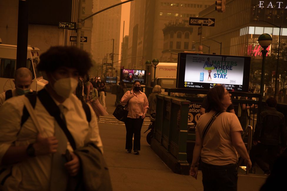Pedestrians wearing face masks walk on a street in New York, US, on 7 June 2023