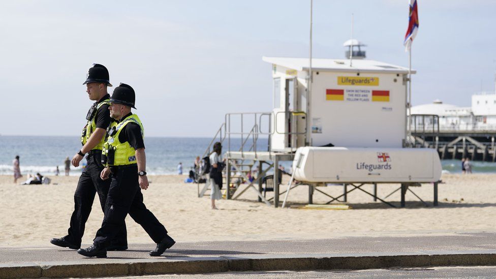 Police officers walk along Bournemouth beach fron