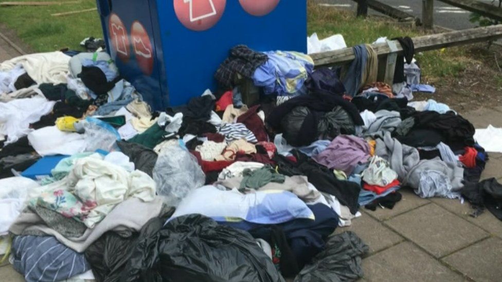 Clothes around a donations bin
