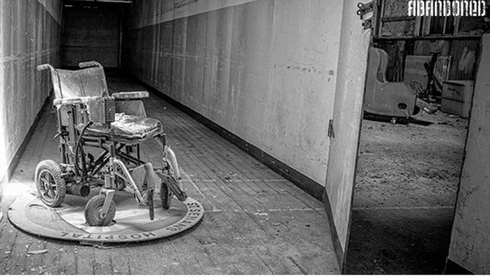 An old wheelchair gathers dust in a deserted asylum
