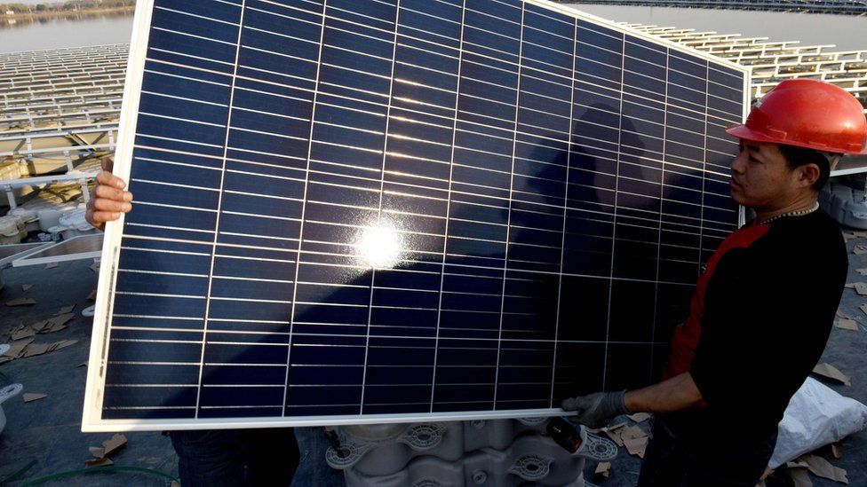 Chinese man carrying solar panel