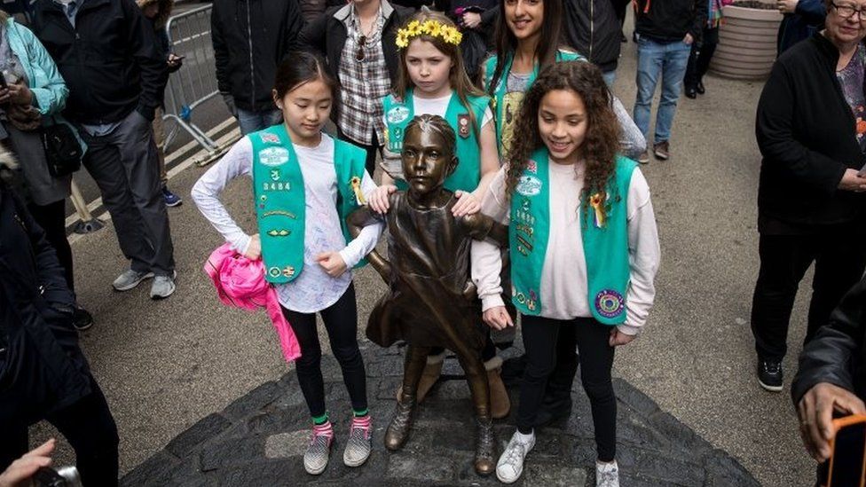 Girls stand next to Fearless Girl. Photo: 27 March 2017