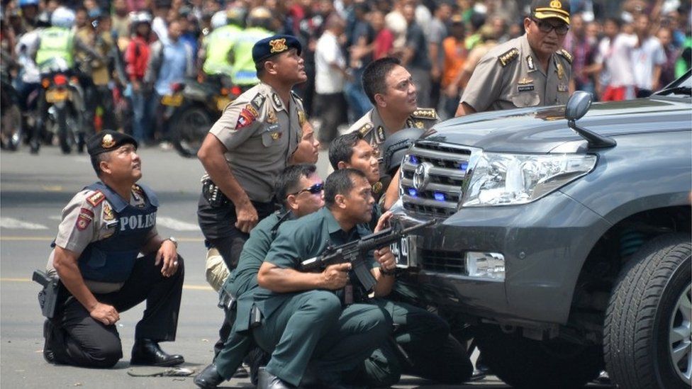 Police hide behind vehicles in Jakarta, Indonesia (14 Jan 2016)