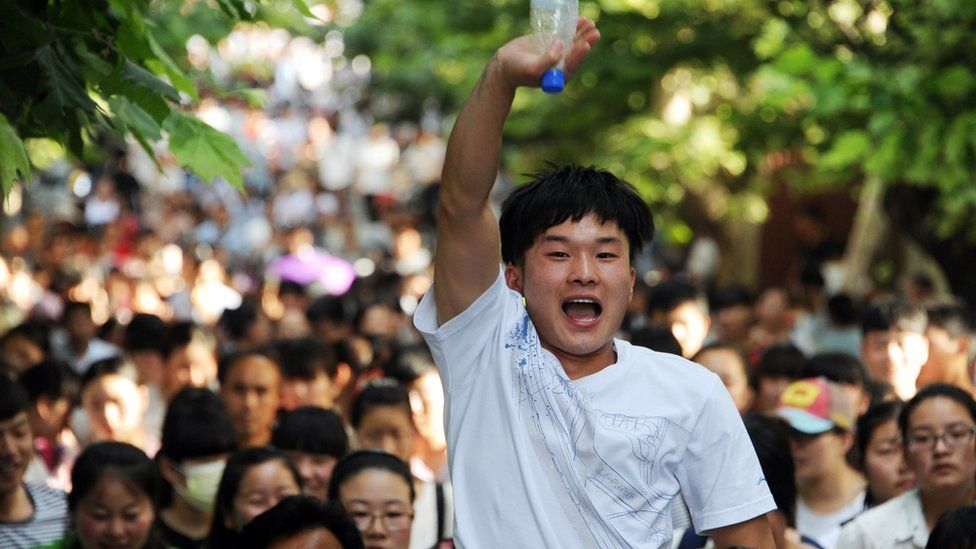 This picture taken on June 8, 2015 shows a high school reacting as they walk out of a school after sitting the 2015 national college entrance examination