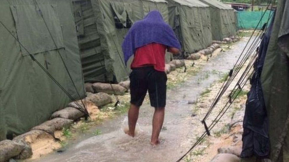 An asylum seeker walks between tents at Australia's detention centre on Manus Island, Papua New Guinea