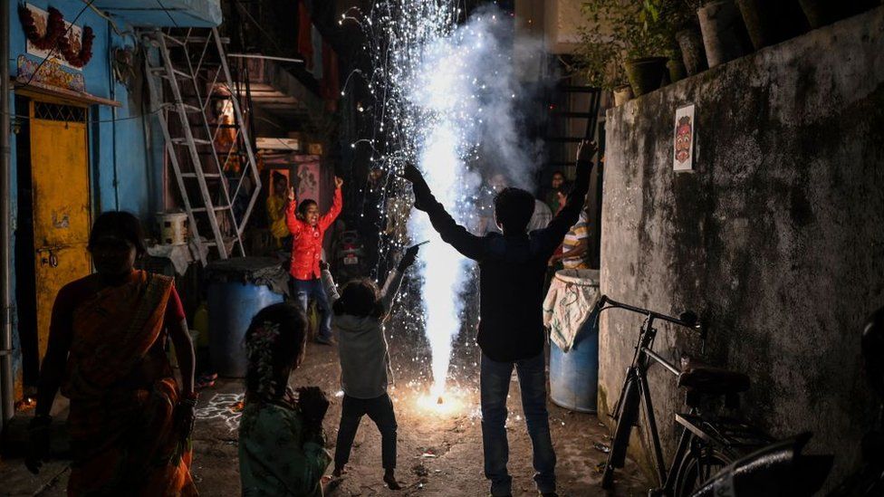 Гуляки зажигают петарды в переулке во время празднования индуистского фестиваля Дивали или Фестиваля огней в Нью-Дели, 4 ноября 2021 года.