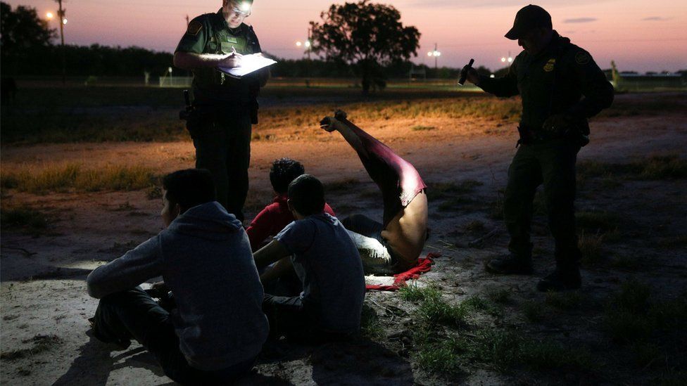 Border patrol agents apprehend immigrants who illegally crossed the border from Mexico into the US on 2 April