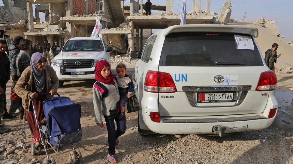 A child stands next to a World Food Programme vehicle in Nashabieh, in the Eastern Ghouta outside Damascus, Syria (28 November 2017)