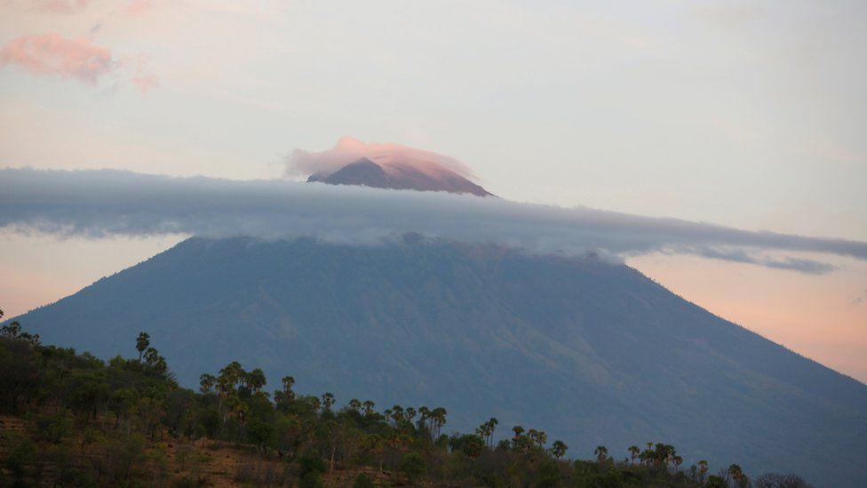 A view of Mount Agung, a volcano on the highest alert level, as the sun rises from Amed on the resort island of Bali, Indonesia, 26 September 2017