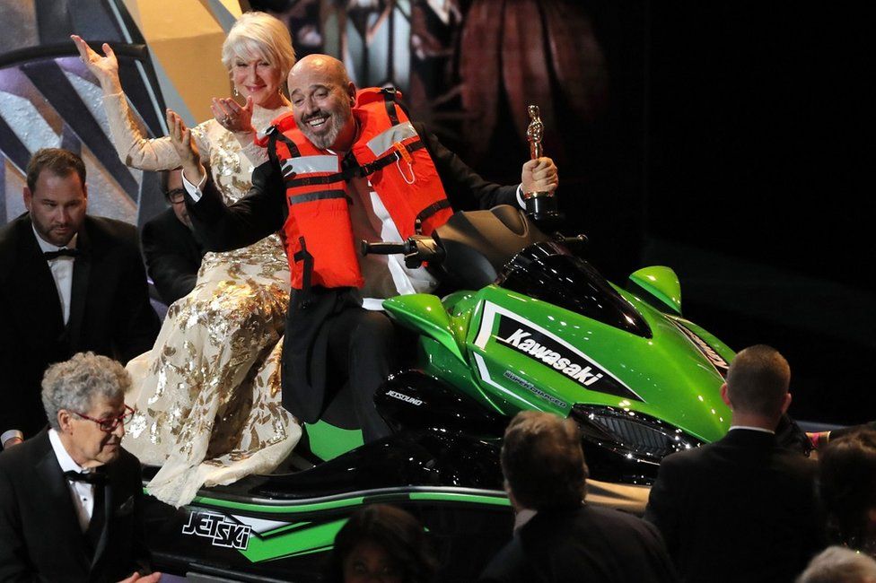 Mark Bridges and Helen Mirren riding a jet ski