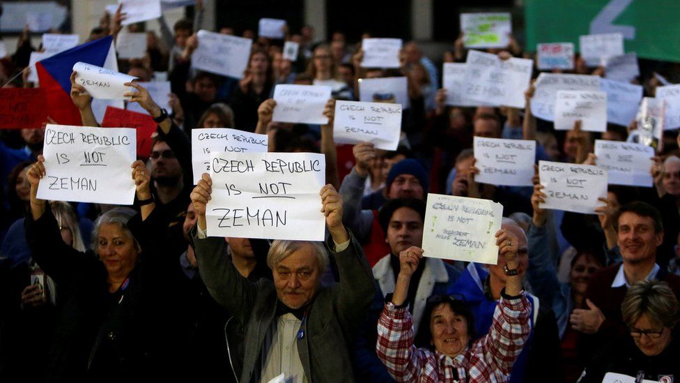 Demonstrators hold signs during a protest rally demanding President Milos Zeman to resign on 17 October 2017
