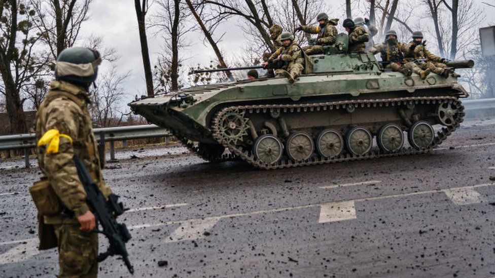 A Ukrainian military vehicle speeds by on a main road near Sytnyaky, Ukraine.